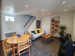 a living room with a table and a couch at La Grange in Bretteville +8 photos