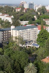 a large white building in a city with trees at The Heron By Sarovar Portico India in Nairobi