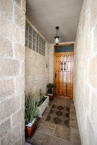 a hallway with a wooden door and potted plants at El Canton De Carlos in Castelserás