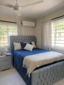 a blue bed in a bedroom with windows at Apartamento Equipado, Wifi, AC, TV @drvacationsrental in San Francisco de Macorís