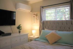 a bedroom with a bed with a television and a window at Apartamento Equipado, Wifi, AC, TV @drvacationsrental in San Francisco de Macorís