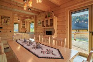 a kitchen with a dining table in a log cabin at Willa Górski Raj - 4 sypialnie, 2 łazienki, sauna, tradycyjna balia in Korbielów