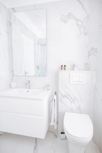 Baño blanco con aseo y lavamanos en Authentic Italian Home, en Cadenabbia