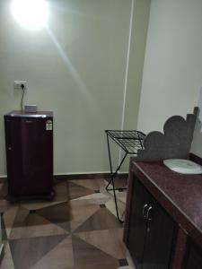 a small refrigerator in a room with a table and a chair at Lucy Guest House in Bogmolo