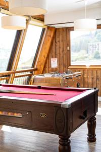 una mesa de billar en una habitación con ventanas en Villages Clubs du Soleil - ORCIERES en Orcières