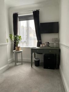 a room with a desk in front of a window at The Millbrook B&B in Torquay