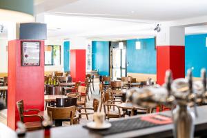 Villages Clubs du Soleil - ORCIERES في أورسيير: مطعم بالطاولات والكراسي والجدران الزرقاء