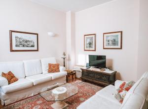 ein Wohnzimmer mit einem weißen Sofa und einem TV in der Unterkunft Authentic Italian Home in Griante Cadenabbia