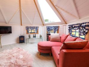 a living room with a red couch and a window at Applejacks Orchard in Holywell