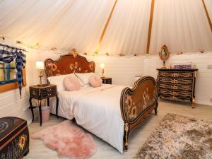 a bedroom with a bed in a tent at Applejacks Orchard in Holywell
