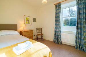 a bedroom with a bed and a window and a chair at Townend Farmhouse - Ullswater in Watermillock