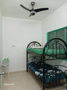 a room with two bunk beds with a ceiling fan at Ees Green Homestay Meru Klang in Kapar