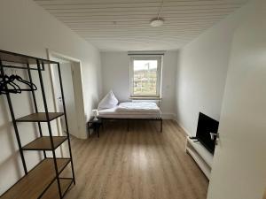 een lege kamer met een bed en een raam bij GuestHouse Bielefeld - Brackwede in Bielefeld