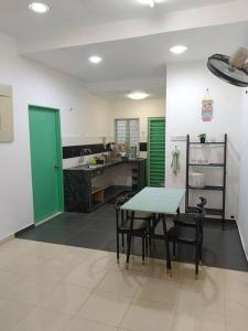 a kitchen with a table and chairs and a sink at Ees Green Homestay Meru Klang in Kapar