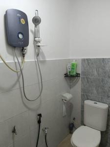 a bathroom with a toilet and a shower in it at Ees Green Homestay Meru Klang in Kapar