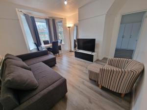 a living room with a couch and two chairs and a television at Comfortable 2 bedrooms flat in Oval Central London in London