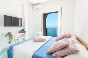 Villa Venere - Amalfi Coast في سيتارا: غرفة نوم مع سرير وإطلالة على المحيط