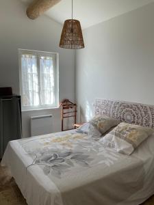 ein Schlafzimmer mit einem Bett mit einer weißen Bettdecke in der Unterkunft La jasse in Cabrières-dʼAigues + 7 Fotos