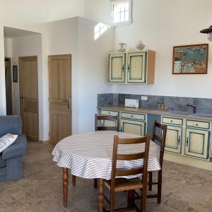 eine Küche mit Tisch und Stühlen in einem Zimmer in der Unterkunft La jasse in Cabrières-dʼAigues