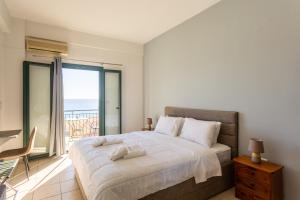 a bedroom with a bed with a view of the ocean at Marina in Kardamyli