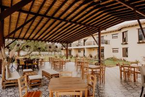 a patio with tables and chairs and a building at Pietra Hotel in Sáchica