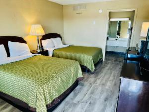 a hotel room with two beds and a television at Travel Inn Bristol near State Street in Bristol