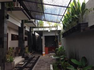a courtyard with plants in a building with a ceiling at Pondok Sutya in Kuta
