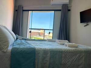 una camera da letto con un letto e una grande finestra di Pousada do Francês a Ubatuba