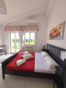 una camera da letto con un grande letto con una coperta rossa e bianca di Villa Nadira a Giardini Naxos