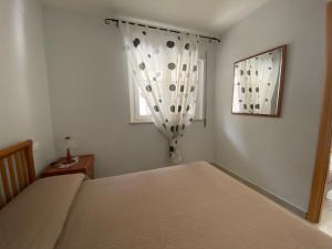 sypialnia z łóżkiem i oknem w obiekcie Appartamento in Villa a Policoro w mieście Policoro