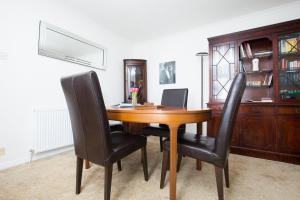 uma mesa de madeira com cadeiras pretas num quarto em GuestReady - Spacious 2BR Flat in Peaceful Hove em Brighton & Hove