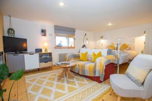 1 dormitorio con cama, sofá y TV en Crofters Retreat 