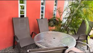 a table and chairs next to a red wall at Luxurious two bathroom apartment Paramaribo, Zorg en Hoop in Paramaribo