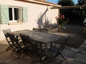 a wooden table and chairs in front of a house at Gite LA FONTAINE Famille Amis Relais Motards in Peyriac-de-Mer +12 photos