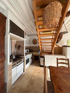 a kitchen with white cabinets and a wooden ceiling at Gite LA FONTAINE Famille Amis Relais Motards in Peyriac-de-Mer