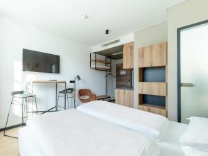 a bedroom with a bed and a flat screen tv at B&B HOTEL Albstadt-Hbf in Albstadt