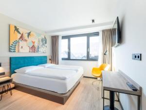 1 dormitorio con cama, mesa y escritorio en B&B HOTEL Albstadt-Hbf, en Albstadt