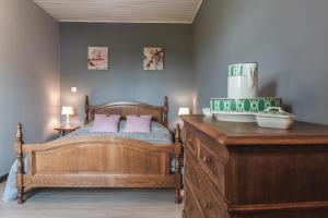 una camera da letto con letto in legno e cuscini rosa di L'Envolée a Chiny