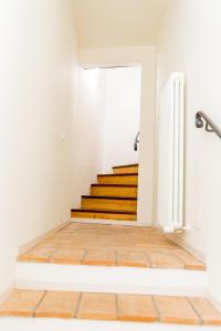 Appartamento in centro Via Porta Fuga في سبوليتو: درج في منزل مع أرضيات خشبية