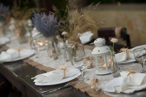 a table with plates and glasses and a lantern on it at Thassos ESPERIA HOTEL in Pefkari