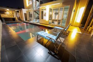 a swimming pool with a chair in the middle of a house at El Amo Lakeview villa in Entebbe