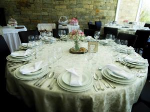 a table with white plates and silverware on it at Hotel Estalagem Turismo in Bragança