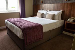 A bed or beds in a room at Arklow Bay Hotel