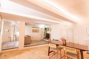 Appartamento in centro Via Porta Fuga في سبوليتو: غرفة معيشة مع طاولة وكراسي خشبية