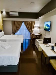 una camera d'albergo con due letti e una televisione di Resort Suite @ Sunway Pyramid by IdealHub a Petaling Jaya