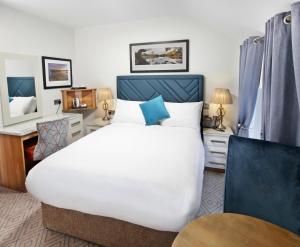 a bedroom with a large white bed and a desk at The Bailie in Cavan