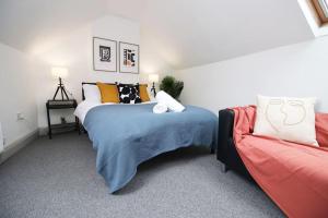 - une chambre avec un lit et un canapé dans l'établissement 2 Bed Flat near Stadium with Street Parking by CTO Serviced Apartments, à Cardiff