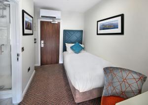 a hotel room with a large bed and a chair at The Bailie in Cavan