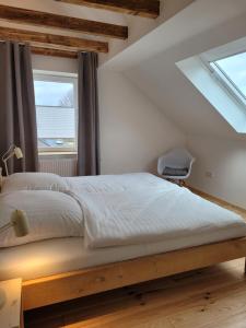 a bedroom with a large bed with a window at Haus Sonnen mit 3 Apartments in Nettetal +18 photos