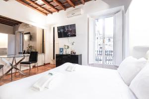 a white bedroom with a white bed and a desk at Collection Spanish Steps Apartments - Top Collection in Rome